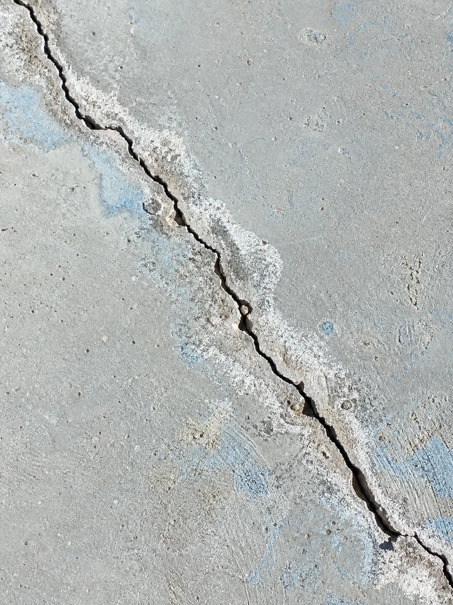 Fissure visible au fond d'un bassin de piscine vidé, révélant un défaut d'étanchéité de la structure
