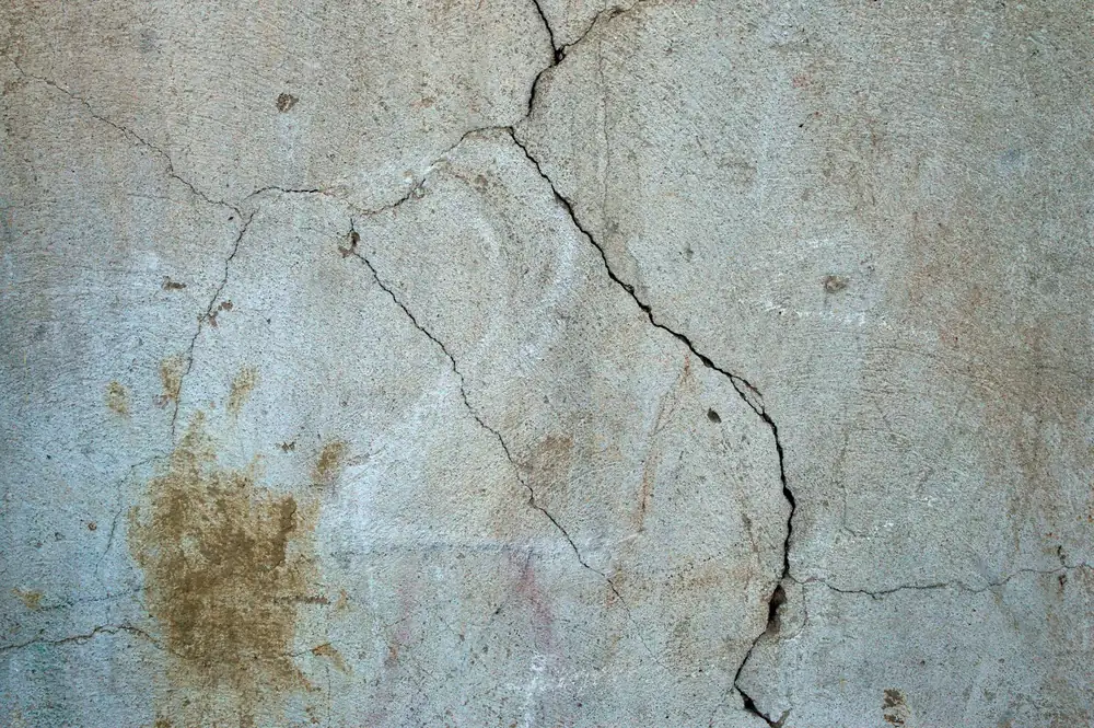 Mur intérieur présentant des fissures et un défaut d'enduit, désordre typique de malfaçon après travaux